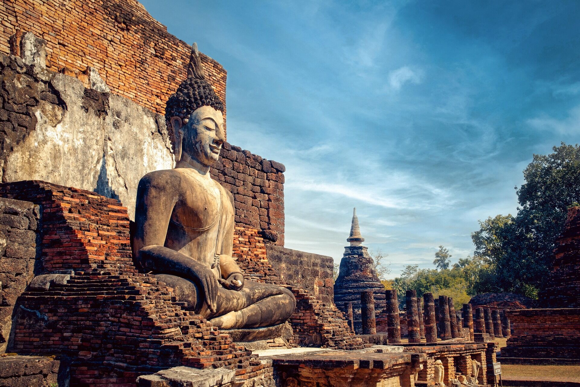 Ancient ruins of Sukhothai Historical Park on a scenic Sukhothai Travel guide banner by Legend Travel Group.
